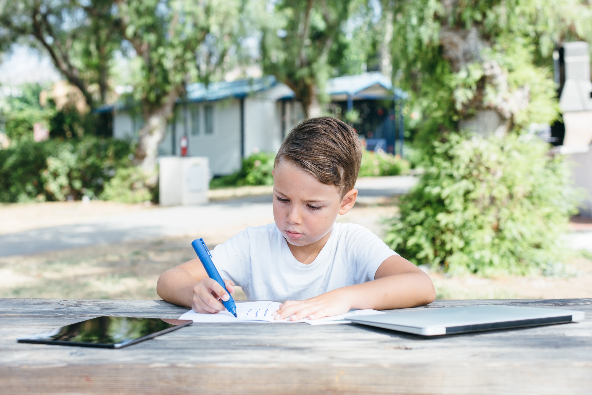 Boy drawing with pen in notebook