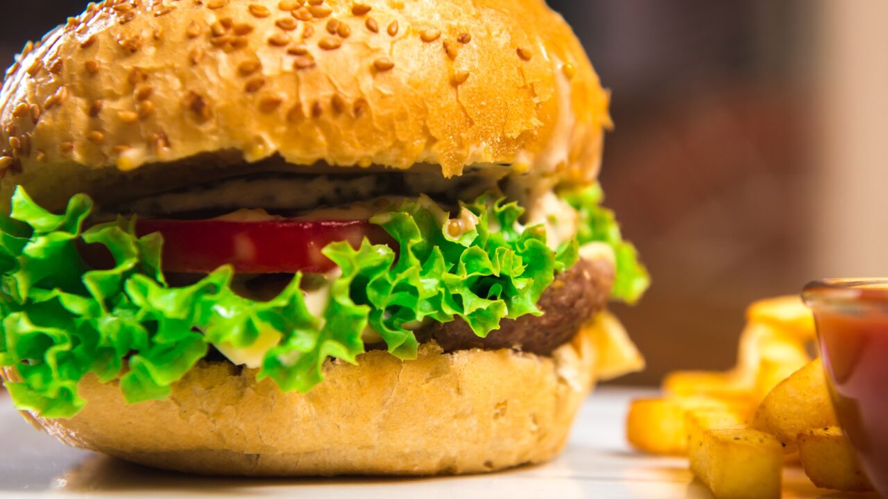 Hamburger with French fries on a wooden table