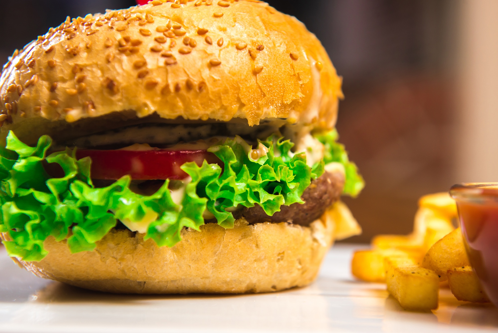Hamburger with French fries on a wooden table