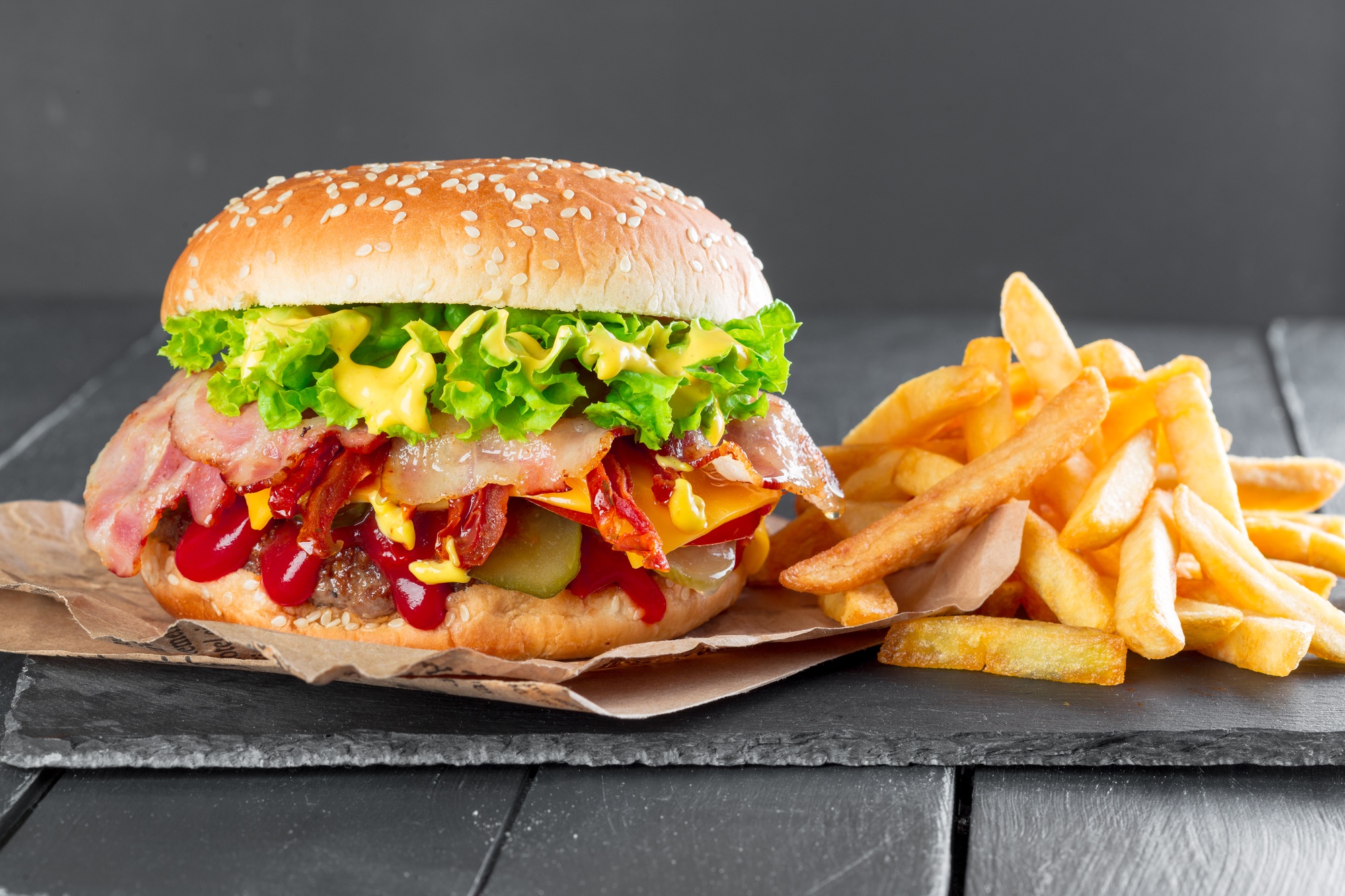 Hamburger with fries on a slate plate