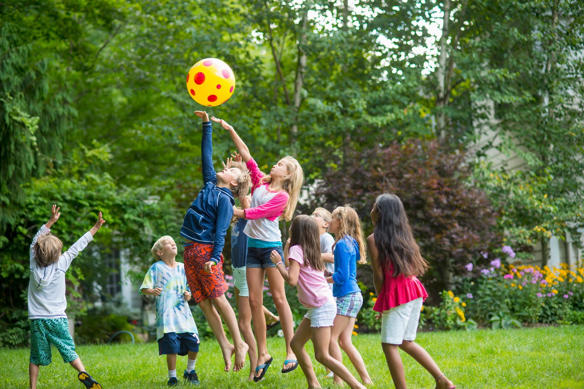 Children playing ball game in garden