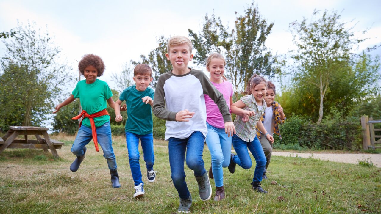 Portrait Of Children On Outdoor Activity Camping Trip Having Fun Playing Game Together