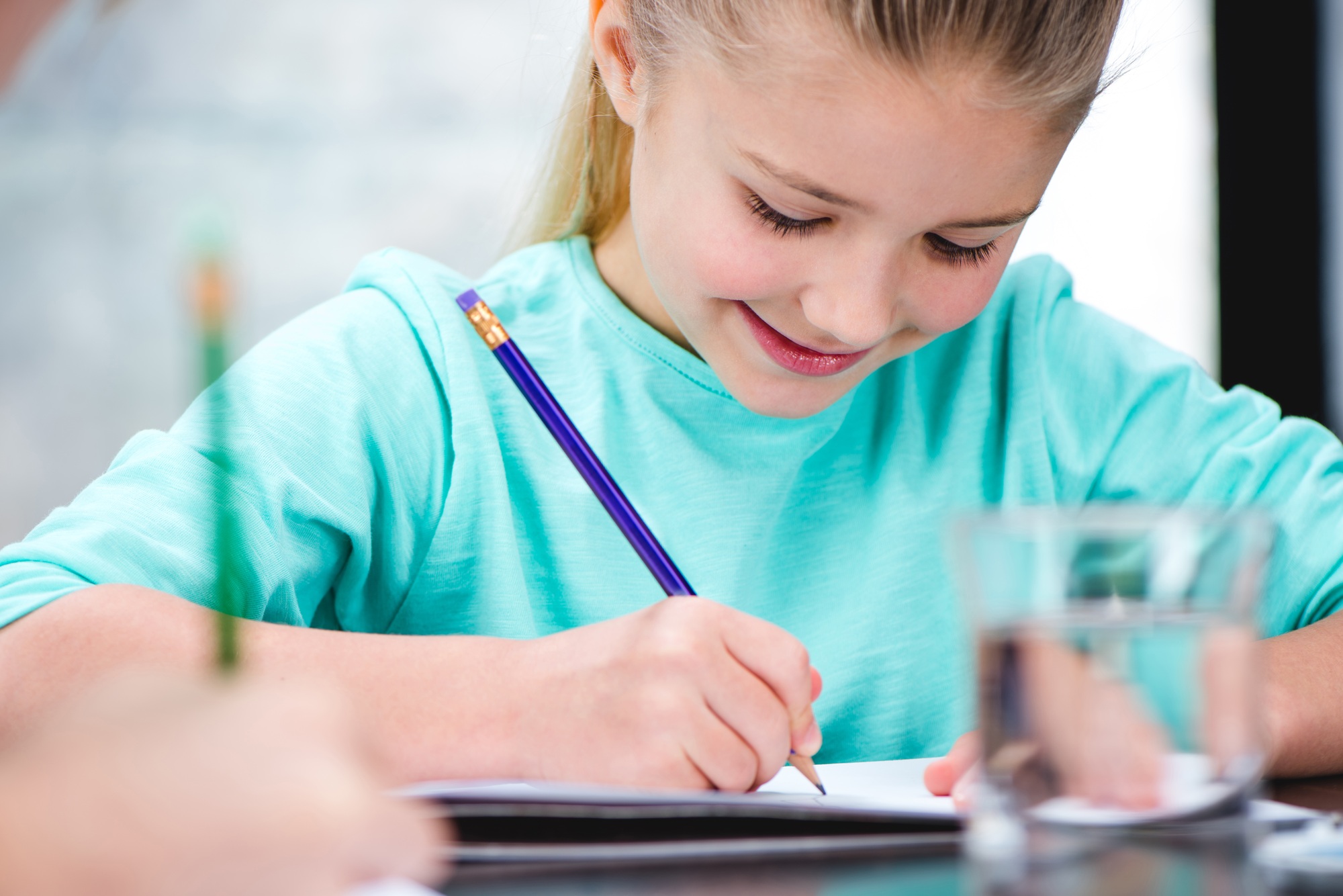 Smiling child drawing picture with pencil