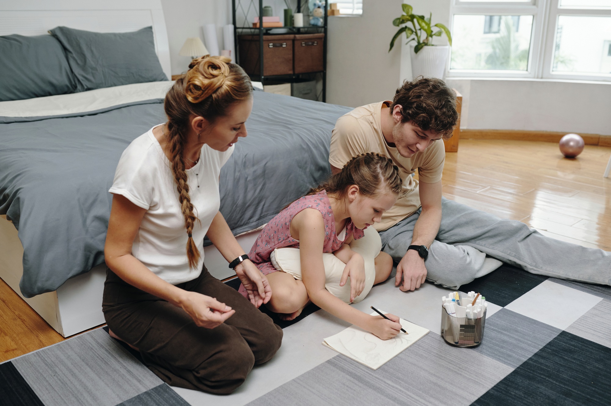 Child Drawing Together With Her Family