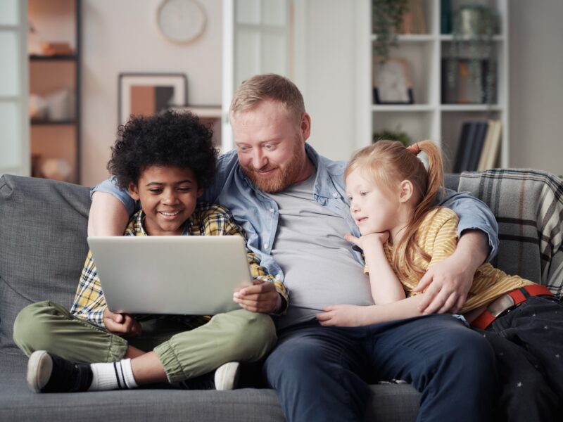 Father with children using laptop at home