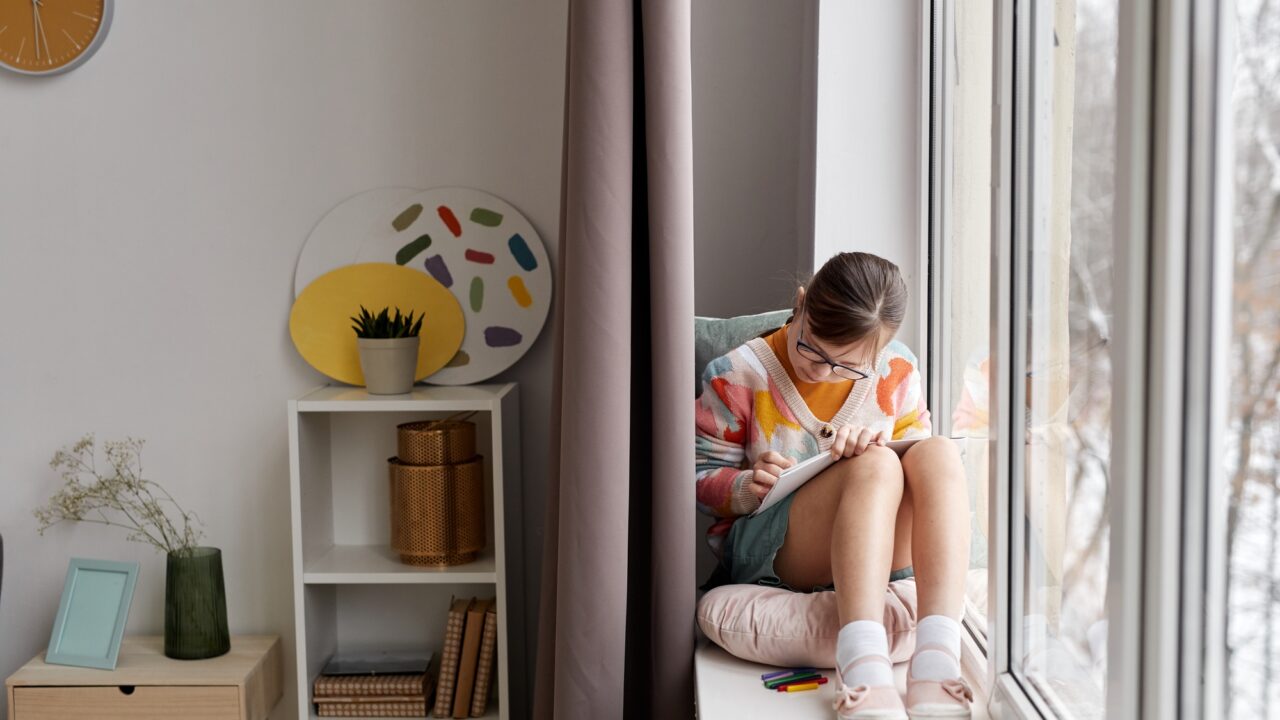 Girl With Down Syndrome Drawing By Window