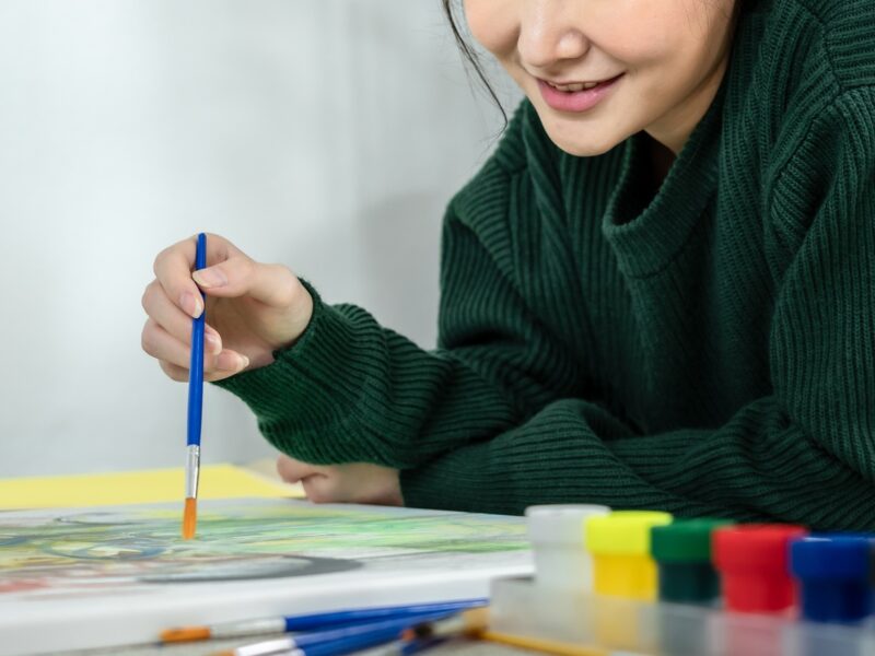 Professional female artist paints on canvas with brushes, Draw with watercolor, Drawing supplies
