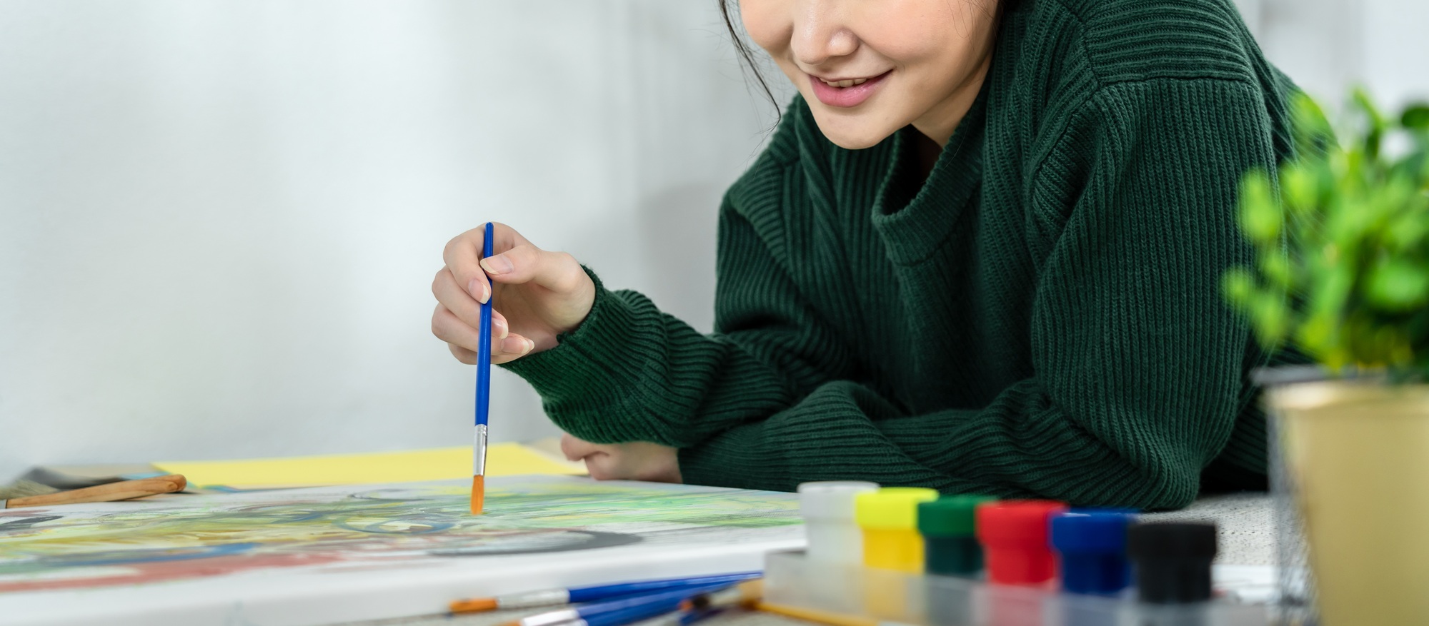 Professional female artist paints on canvas with brushes, Draw with watercolor, Drawing supplies