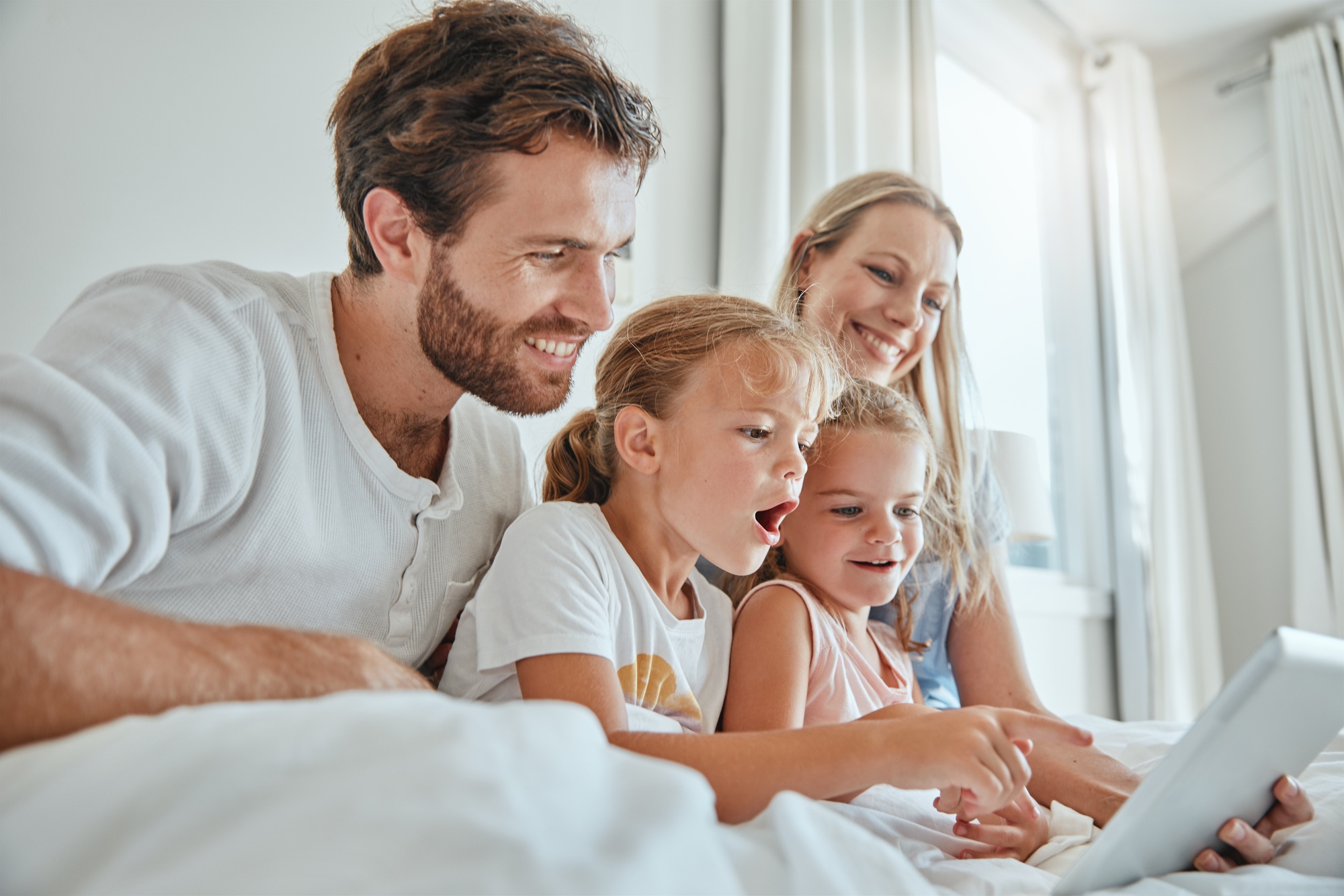 Tablet, children and family in bed with a mother, father and daughter siblings streaming online con
