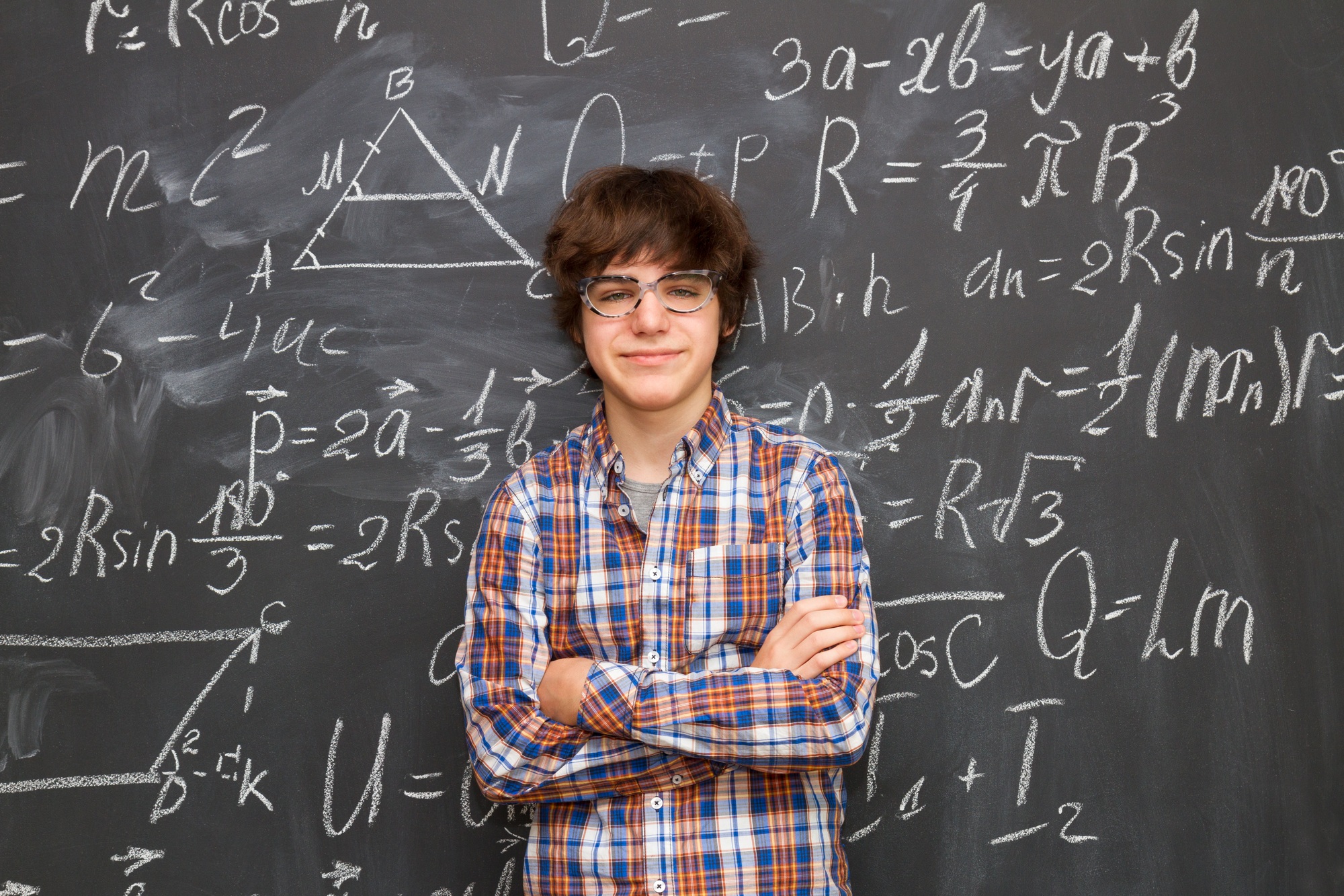 Boy and blackboard filled with math formulas