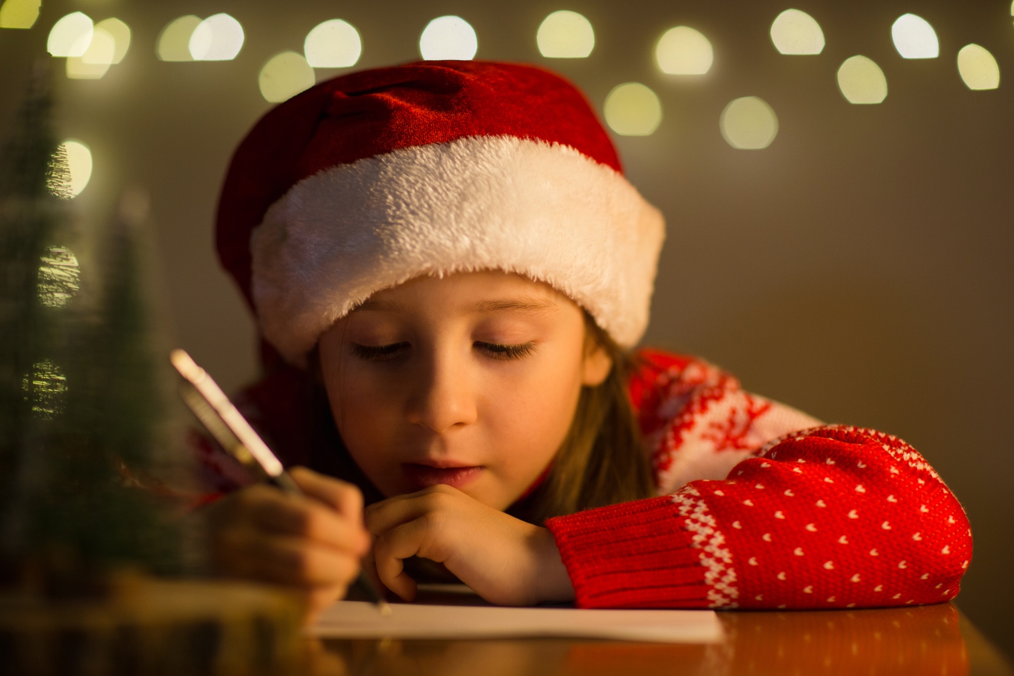 child draws on christmas letter.