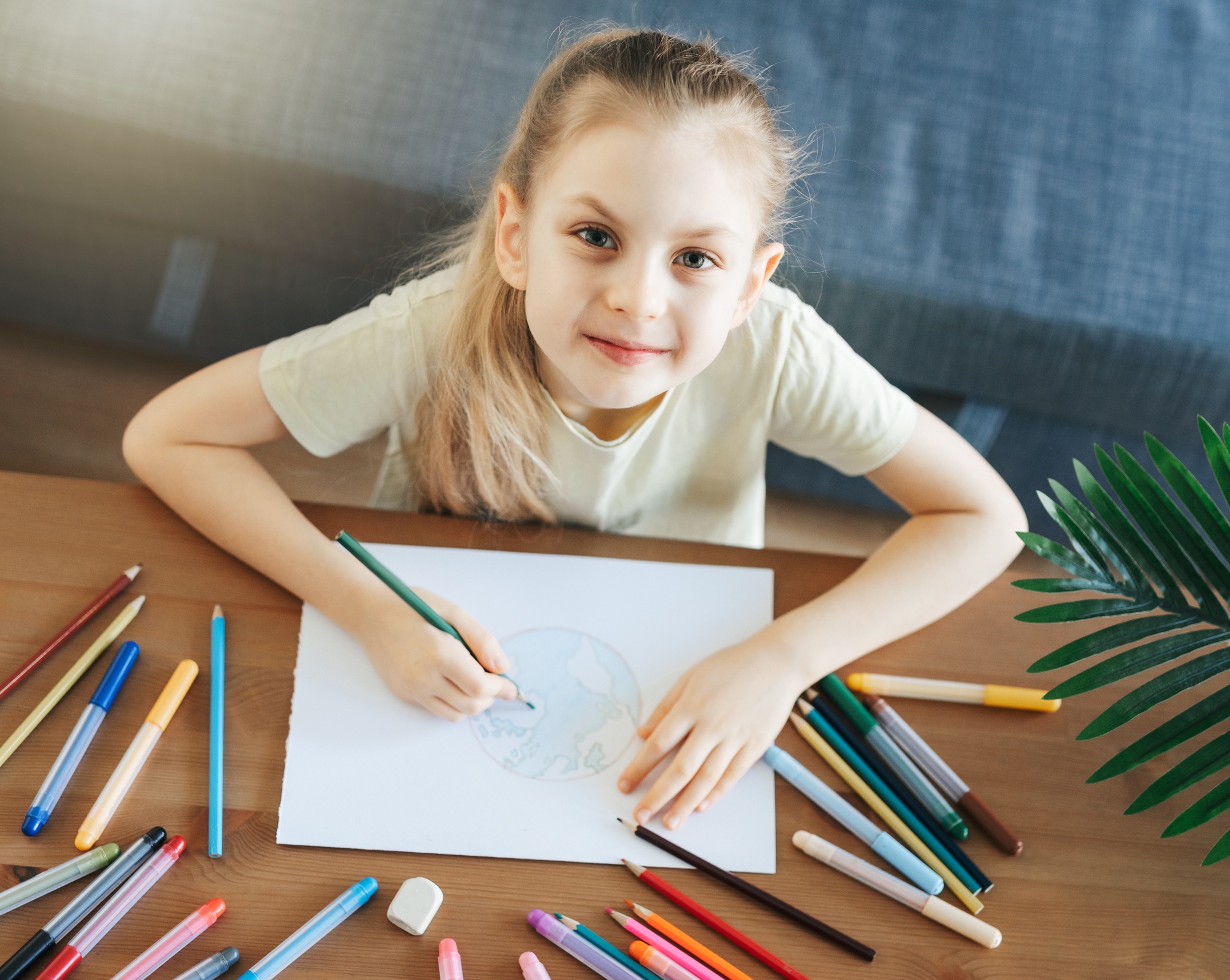 Child girl drawing with colorful pencils