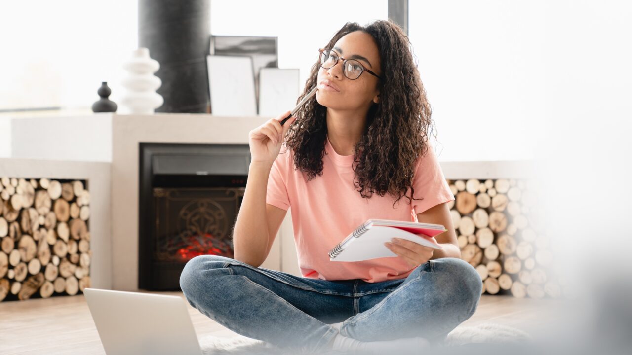 Dreamy thoughtful pensive young woman author student doing paperwork, writing poetry novels