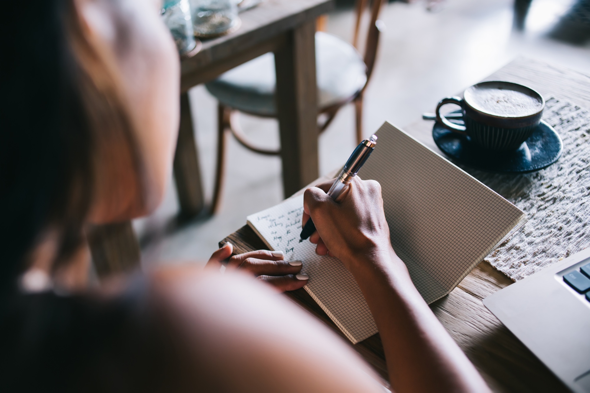 Female author composing letter in notepad