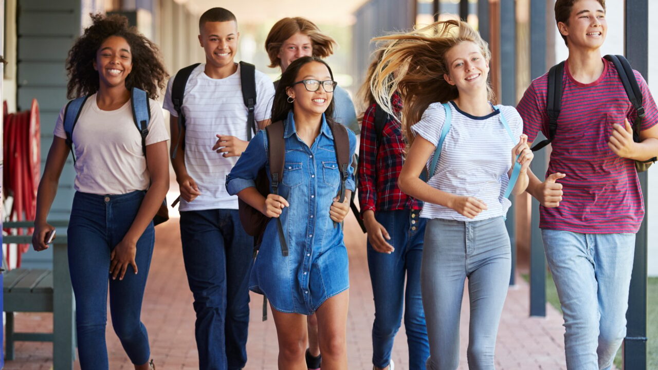 Teenager school kids running in high school hallway